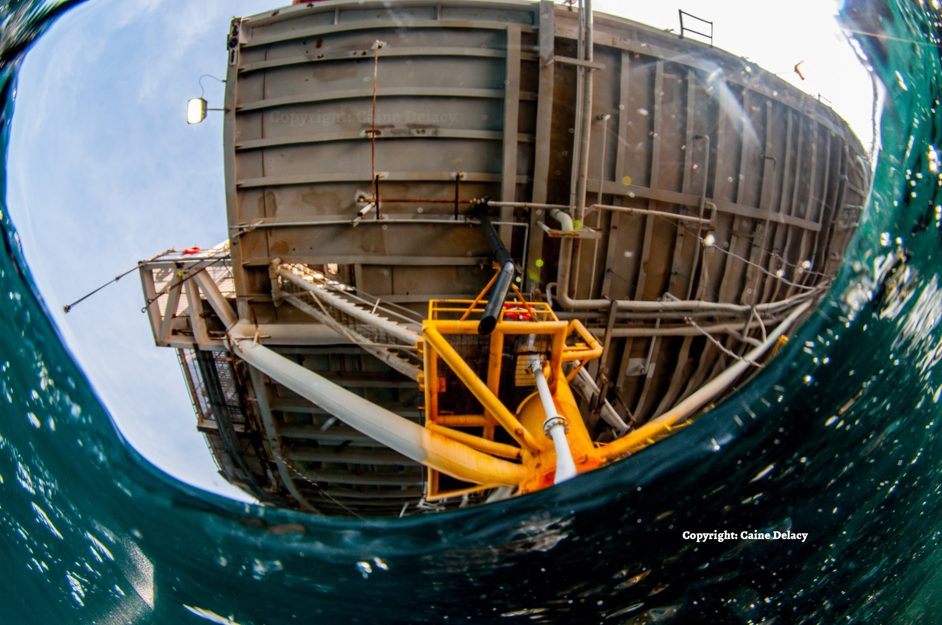 A photo of the underside of an oil rig, taken just beneath the surface of the water